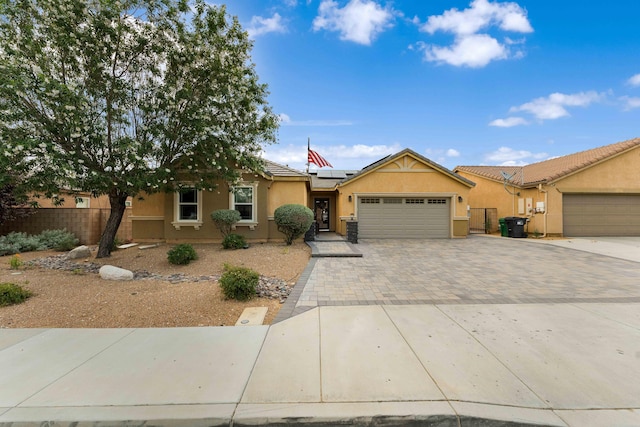 ranch-style home featuring a garage and solar panels