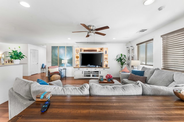 living room featuring ceiling fan and dark hardwood / wood-style floors