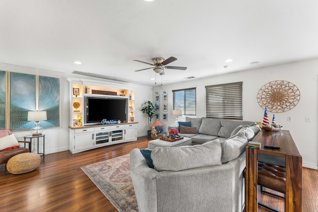 living room featuring dark wood-type flooring and ceiling fan