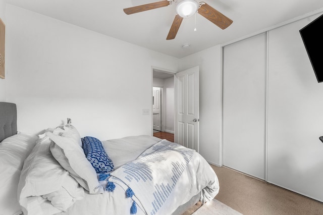 carpeted bedroom with ceiling fan and a closet