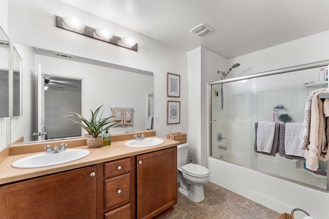 full bathroom with vanity, enclosed tub / shower combo, and toilet