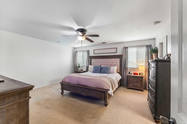 bedroom featuring multiple windows, ceiling fan, and light carpet