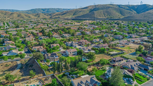 aerial view of property's location with a mountain backdrop and nearby suburban area