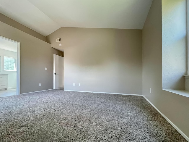 empty room featuring carpet flooring and vaulted ceiling