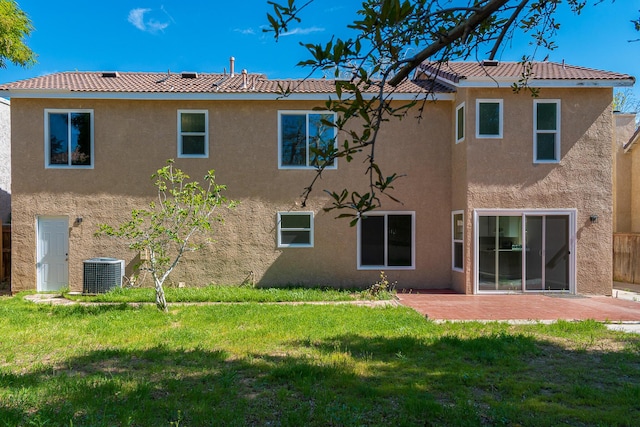 back of property featuring a lawn, central AC unit, and a patio