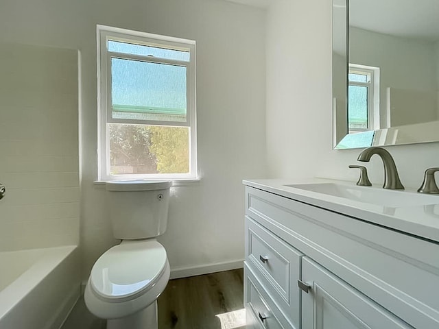 full bathroom with hardwood / wood-style flooring, vanity, toilet, and washtub / shower combination