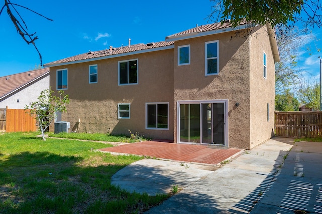 rear view of property with a lawn, central air condition unit, a patio, and a wooden deck