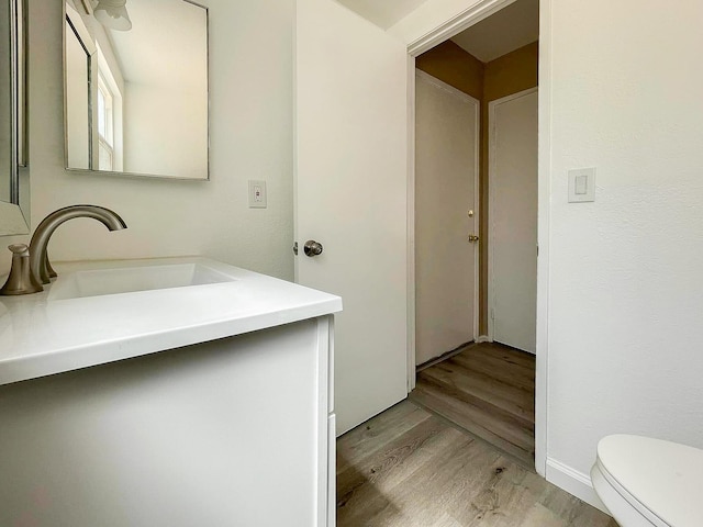 bathroom featuring hardwood / wood-style floors, vanity, and toilet