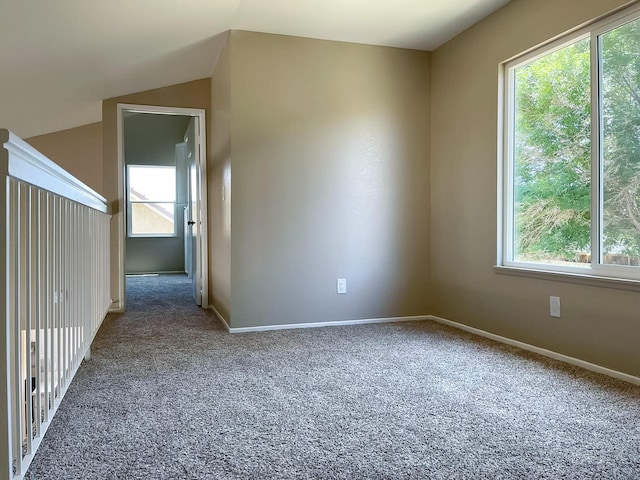 unfurnished room featuring carpet flooring and vaulted ceiling