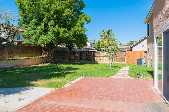 view of yard with central air condition unit and a patio area