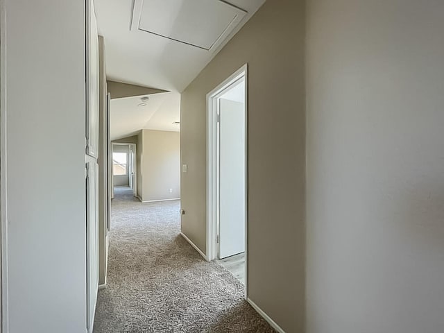 hallway with light colored carpet and lofted ceiling