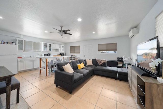 living area with light tile patterned floors, recessed lighting, ceiling fan, and a wall unit AC