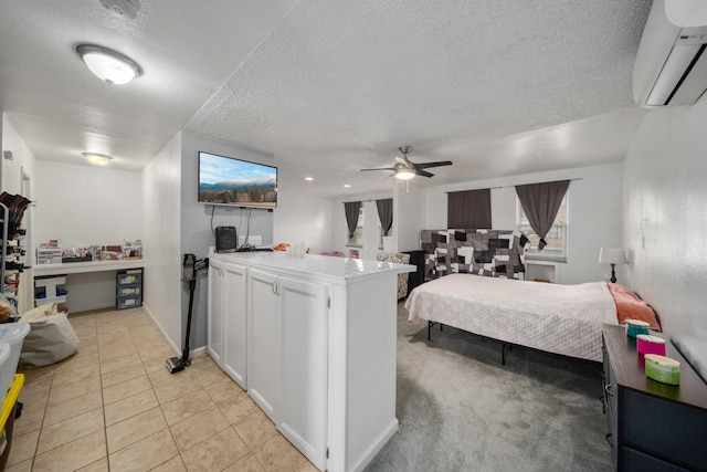 bedroom featuring light tile patterned floors, baseboards, a wall mounted AC, ceiling fan, and a textured ceiling