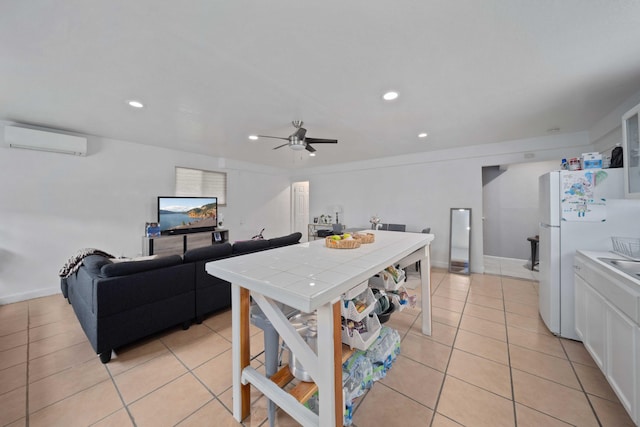 kitchen with a wall mounted AC, white cabinetry, light tile patterned flooring, tile counters, and ceiling fan