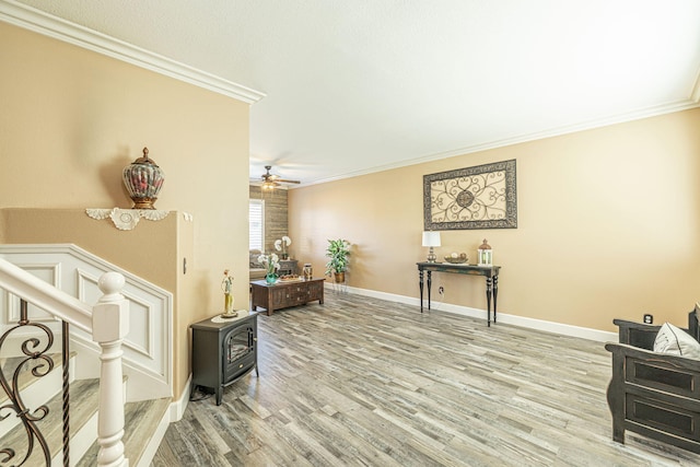 interior space featuring ornamental molding, stairway, wood finished floors, and a wood stove