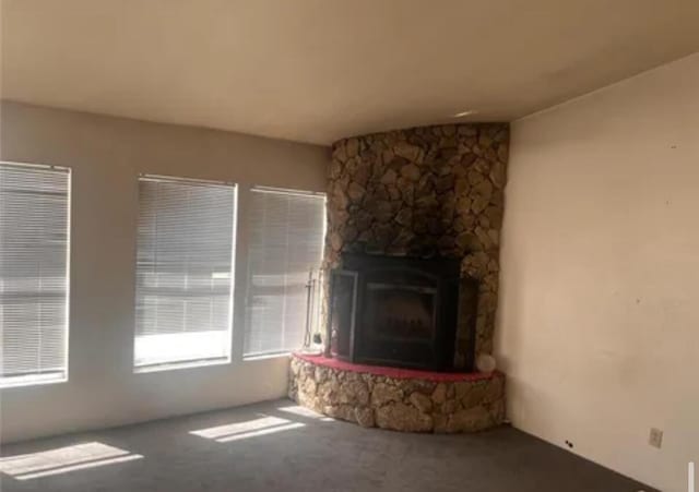 unfurnished living room with a stone fireplace