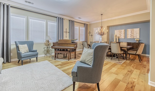 living room featuring wood-type flooring, crown molding, and an inviting chandelier