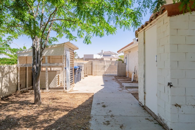 view of yard featuring a gate, fence, and an outdoor structure