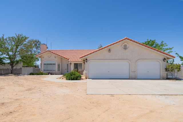 mediterranean / spanish-style house featuring concrete driveway, a chimney, a tile roof, and stucco siding