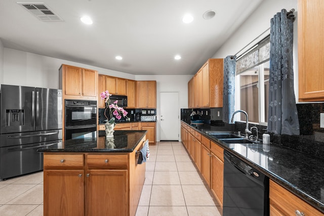 kitchen featuring dark stone countertops, sink, black appliances, and a kitchen island