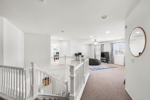 hallway featuring carpet and a textured ceiling