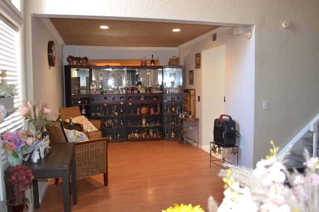 interior space featuring wood-type flooring and crown molding