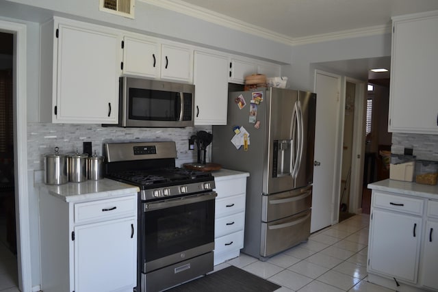 kitchen with tasteful backsplash, white cabinets, and stainless steel appliances