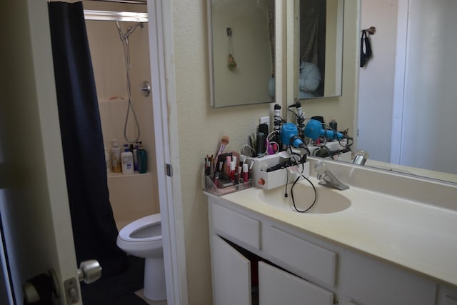 bathroom featuring vanity, curtained shower, and toilet