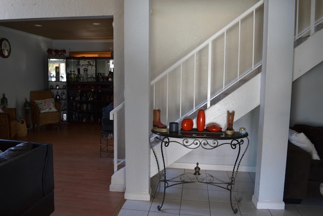 staircase featuring crown molding and hardwood / wood-style flooring