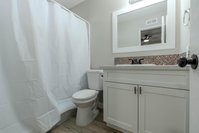 bathroom featuring visible vents, a shower with shower curtain, toilet, vanity, and wood finished floors