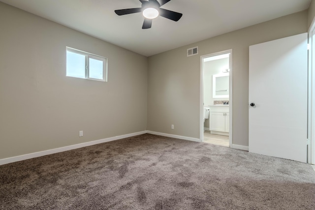 unfurnished room with baseboards, visible vents, light colored carpet, ceiling fan, and a sink