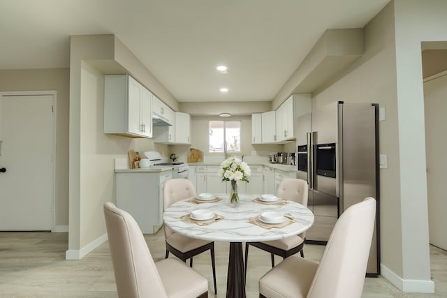 dining area with light wood finished floors and baseboards