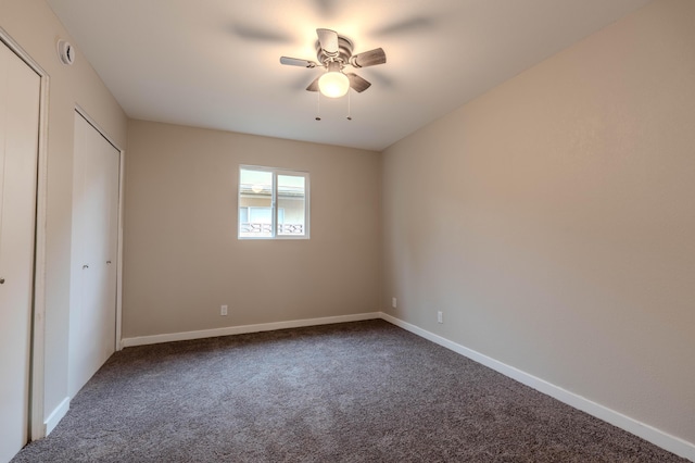 unfurnished bedroom featuring dark carpet, a ceiling fan, and baseboards