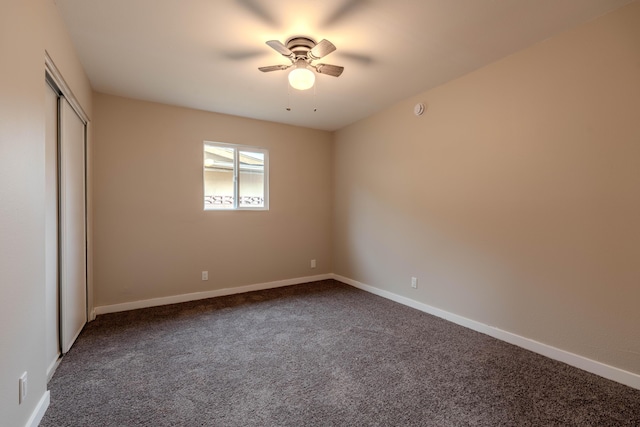 unfurnished bedroom featuring a closet, dark carpet, and baseboards