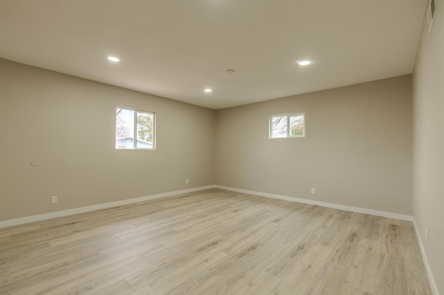 unfurnished room featuring light wood-style floors, recessed lighting, a healthy amount of sunlight, and baseboards