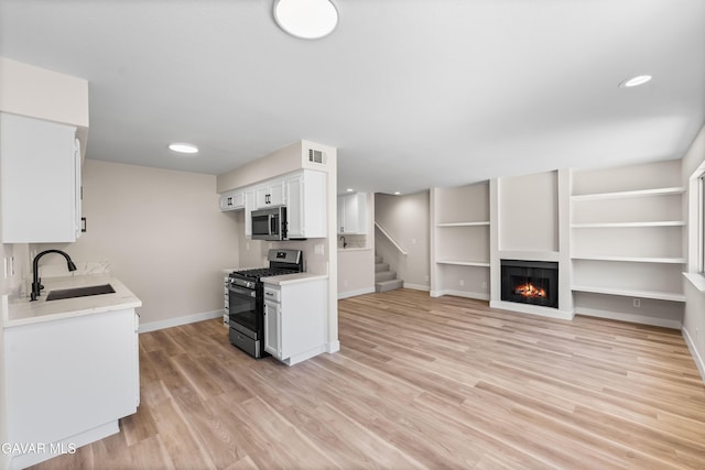 43441 W 30th St Unit 3, Lancaster, CA 93536 - kitchen featuring stainless steel appliances, light countertops, white cabinets, light wood-style flooring, and recessed lighting