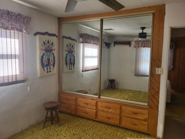 carpeted bedroom featuring a closet, ceiling fan, and multiple windows