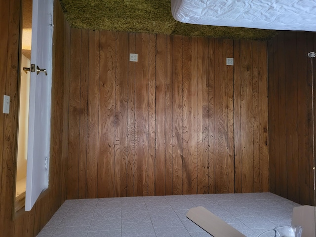 unfurnished room with a textured ceiling and wooden walls