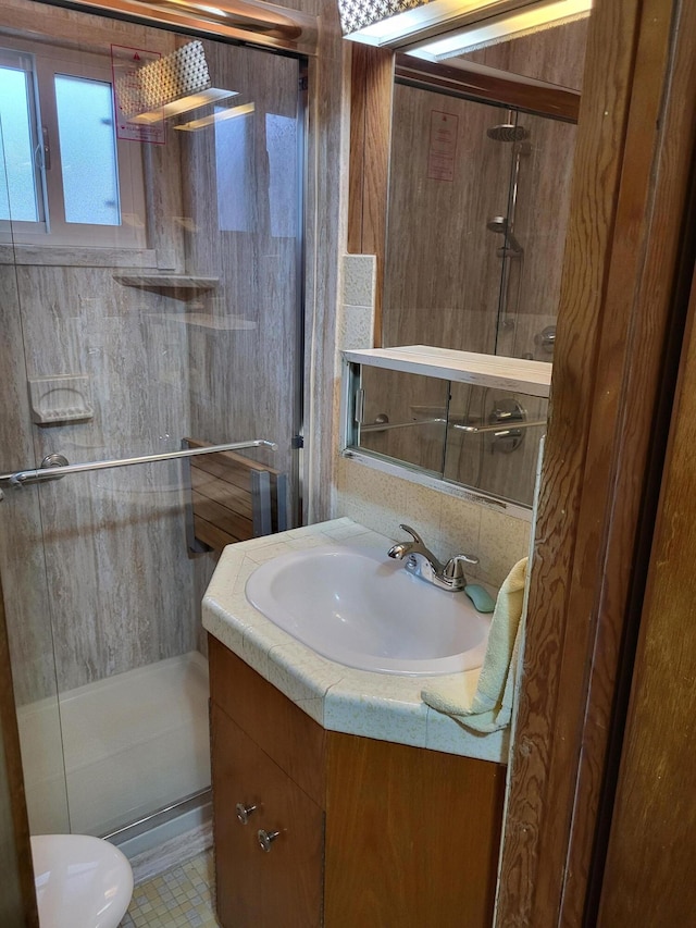 bathroom featuring vanity, toilet, and a shower with door