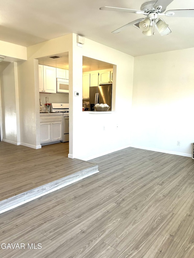 38710 E 10th St Unit 12, Palmdale, CA 93550 - unfurnished living room with light wood-style floors and a ceiling fan