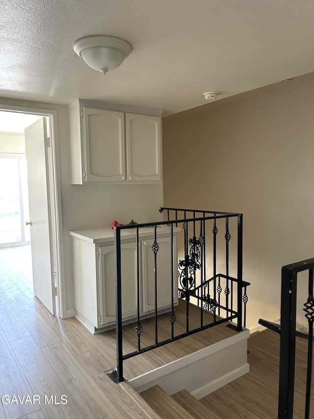 38710 E 10th St Unit 12, Palmdale, CA 93550 - stairway featuring wood finished floors and a textured ceiling