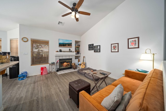 2908 Owens Way, Rosamond, CA 93560 - living area with wood finished floors, ceiling fan, baseboards, a tile fireplace, and high vaulted ceiling