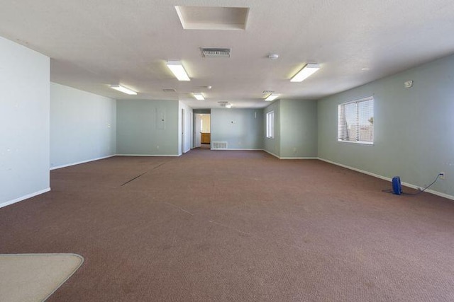 carpeted spare room with visible vents and baseboards