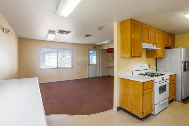 kitchen featuring brown cabinets, under cabinet range hood, white range with gas stovetop, and light countertops