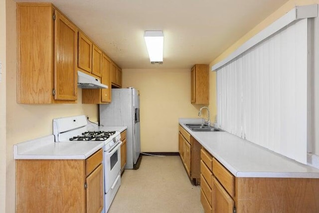 kitchen with light countertops, brown cabinetry, a sink, white appliances, and under cabinet range hood