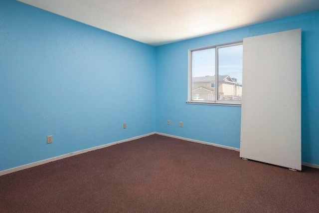 carpeted empty room with baseboards