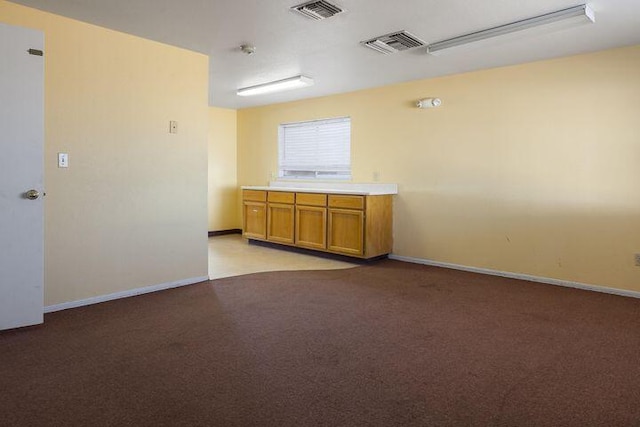 empty room featuring light carpet, visible vents, and baseboards