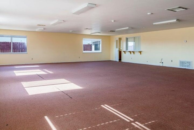 unfurnished room featuring a healthy amount of sunlight and visible vents