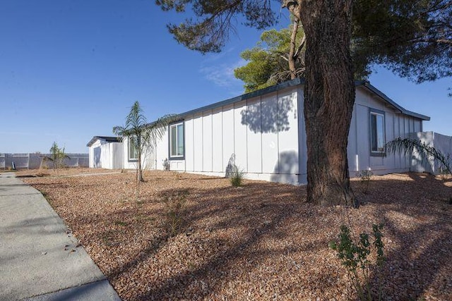 view of property exterior featuring fence and board and batten siding