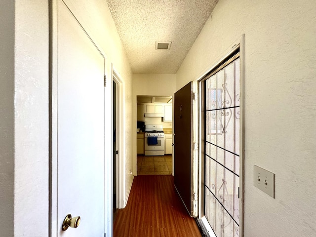 44200 Kingtree Ave Unit 6, Lancaster, CA 93534 - hallway with a textured ceiling, a textured wall, and dark wood-type flooring